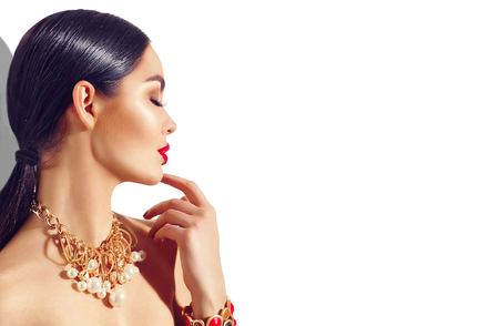 Beauty fashion brunette model girl portrait. Sexy young woman with perfect makeup and trendy golden accessoriesの写真素材