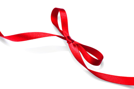 Valentine gift red tape bow. Elegant red satin gift ribbon isolated on whiteの写真素材