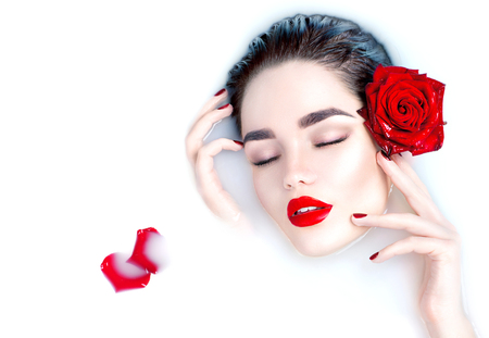 Beautiful fashion model girl taking milk bath, spa and skin care conceptの写真素材