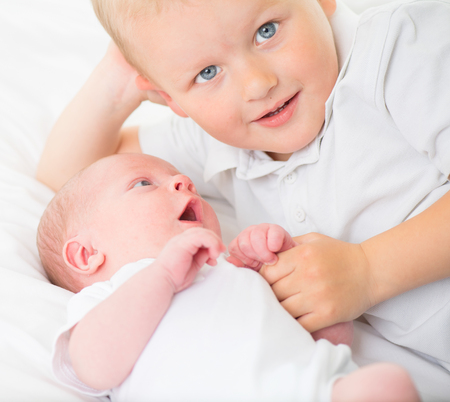 Newborn baby with older brother together. Happy family portraitの写真素材