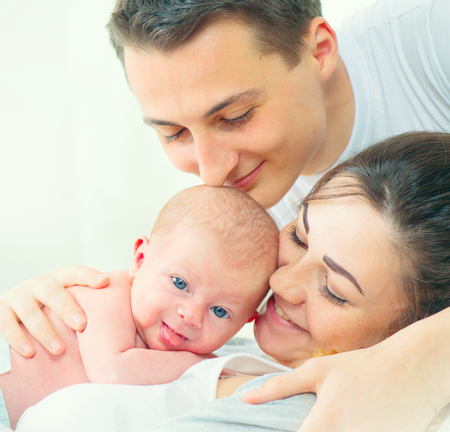 Happy young family. Father, mother and their newborn baby. Parenthood conceptの写真素材
