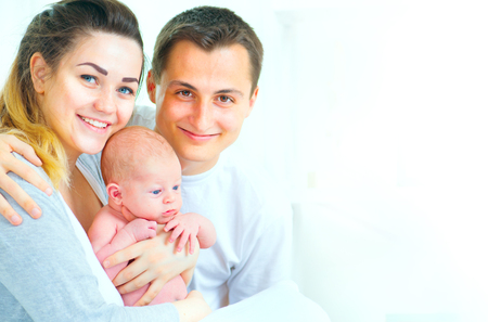 Happy young family. Father, mother and their newborn baby. Parenthood conceptの写真素材