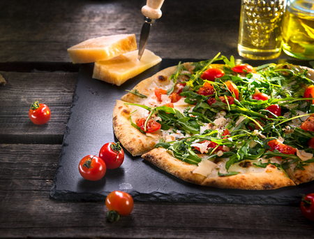 Pizza Caprese with arugula, cheese, yoghurt and cherry tomatoes closeupの写真素材
