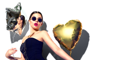 Party. Beautiful fashion model girl with colorful heart and star shaped balloons isolated on white backgroundの写真素材