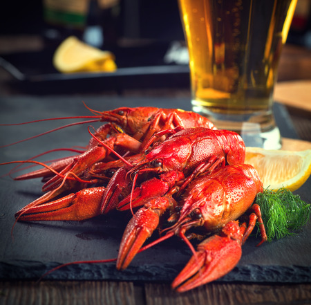 Red boiled crayfish with lemon and herbs on stone slate. Crawfish closeupの写真素材