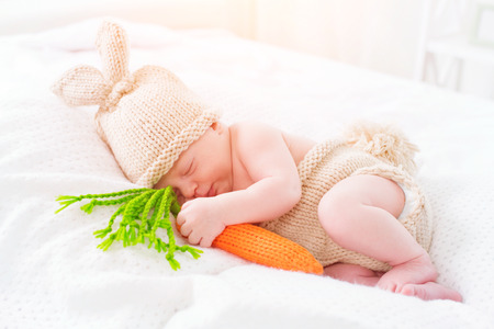 Cute two weeks old newborn baby boy wearing knitted bunny costume. Sweet baby portraitの写真素材