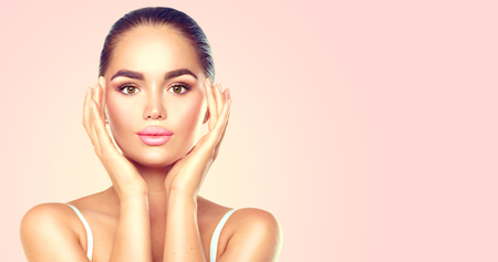 Beauty brunette spa woman touching her face. Skincare conceptの写真素材