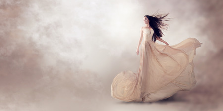 Fashion model in beautiful luxury beige flowing chiffon dressの写真素材