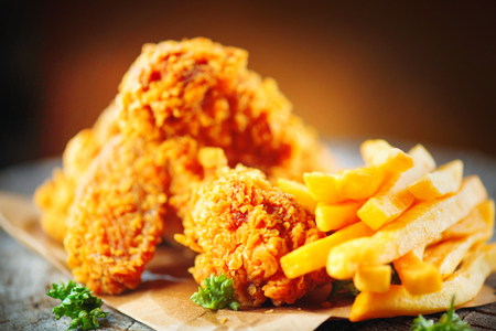 Fried chicken wings and legs on wooden table. Closeup of tasty fried chickenの写真素材