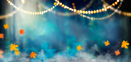 Fantasy Halloween holiday background. Dark misty forest decorated with light garlandsの写真素材