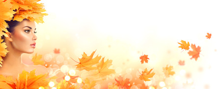 Autumn woman. Fall. Beauty model girl with autumn bright leaves hairstyleの写真素材
