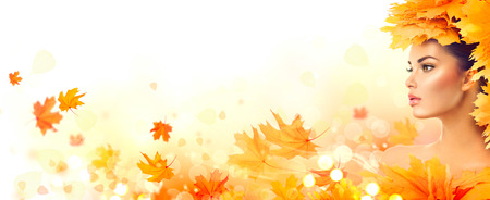Autumn woman. Fall. Beauty model girl with autumn bright leaves hairstyleの写真素材