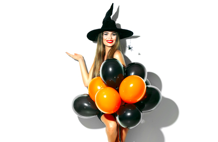 Halloween. Sexy witch holding black and orange air balloonsの写真素材