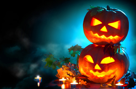 Halloween holiday background. Curved Halloween pumpkins with burning candlesの写真素材