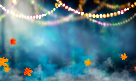 Fantasy Halloween background. Beautiful autumnal forest with garlands and falling leavesの写真素材