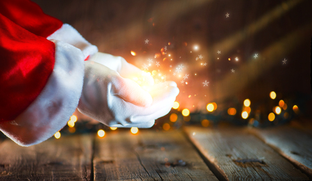 Christmas scene. Santa Claus showing glowing stars and magic dust in open hands. Proposing productの写真素材