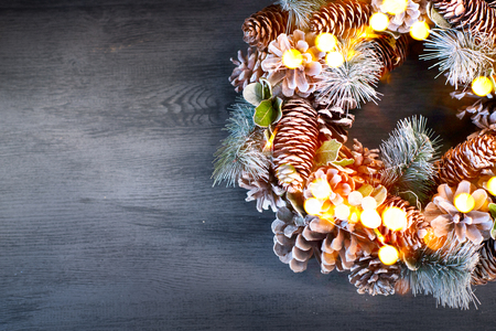 Christmas vintage background. Holiday evergreen tree wreath decorated on dark wooden tableの写真素材