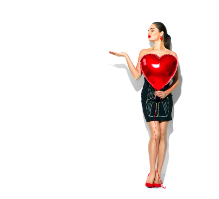 Valentine's Day. Beauty girl with red heart shaped air balloon, isolated on white backgroundの写真素材