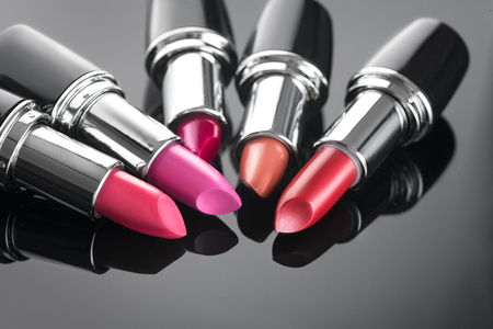 Lipstick. Professional makeup and beauty. Lipstick tints palette closeup. Colorful lipsticks over black backgroundの写真素材
