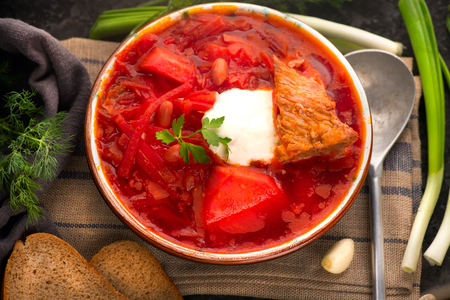Traditional Ukrainian russian borscht. Plate of red beet root soup borsch on black rustic table. Beetroot soup top view. Traditional Ukrainian cuisineの写真素材