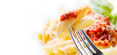 Pasta. Penne pasta with bolognese sauce, parmesan cheese and basil closeup. Italian cuisineの写真素材