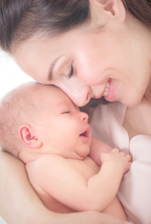 Mother and her newborn baby together. Happy mother and baby kissing and hugging. Maternity concept. Parenthoodの写真素材