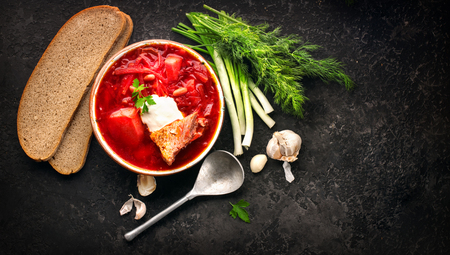 Traditional Ukrainian russian borscht. Plate of red beet root soup borsch on black rustic table. Beetroot soup top view. Traditional Ukrainian cuisineの写真素材