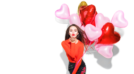 Valentine's Day. Beauty girl with colorful air balloons having fun, isolated on white backgroundの写真素材
