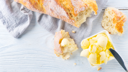 Butter and fresh crunchy homemade bread. Healthy organic breakfast on rustic white wooden table. Top view, flatlayの写真素材