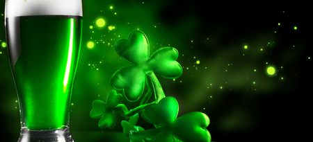 St. Patrick's Day. Green beer pint over dark green background, decorated with shamrock leaves. Traditional Irish festivalの写真素材