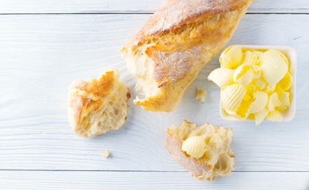 Butter and fresh crunchy homemade bread. Healthy organic breakfast on rustic white wooden table. Top view, flatlayの写真素材