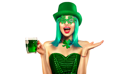 St. Patrick's Day. Leprechaun model girl with pint of green beer over white background. Patrick Day celebrationの写真素材