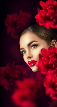 Beautiful girl with red peony flowers portrait. Beauty fashion model woman face closeupの写真素材