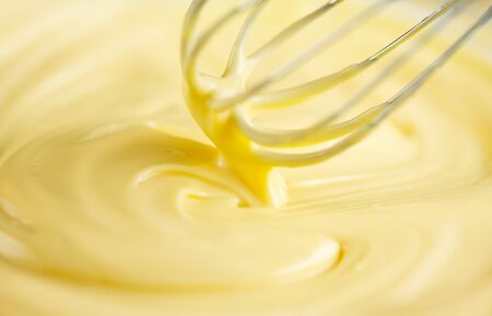 White chocolate. Melted liquid white chocolate mixing with a wisk.の写真素材