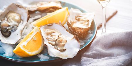 Fresh Oysters closeup, served with oysters, lemon and ice. Healthy seafood. Oyster dinner in restaurant. Gourmet foodの写真素材