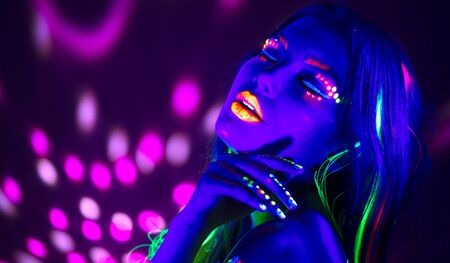 Fashion disco woman. Dancing model in neon light, portrait of beauty girl with fluorescent makeup. Art designの写真素材