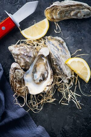 Oyster. Fresh oysters closeup with knife. Oyster dinner in restaurant.の写真素材
