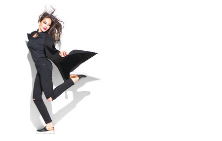 Beautiful young brunette woman in trendy outfit, fashion make up and accessories isolated on white background. Beauty model girl posing in fashionable clothes. Urban style, total blackの写真素材