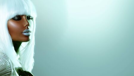 High Fashion model girl in colorful bright neon lights posing in studio, portrait of beautiful African American woman in white hairの写真素材
