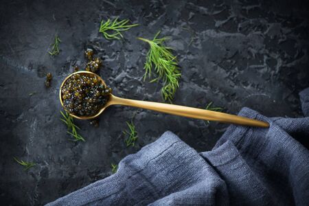 Black Caviar in a spoon on dark background. High quality real natural sturgeon black caviar close-up. Delicatessen. Texture of expensive luxury caviar. Food Backdrop. Top view, flatlayの写真素材