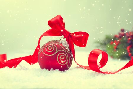 Christmas. Christmas and New Year Holiday Background with Red Bauble, Ribbon, Snow and Snowflakes. Vintage style Xmas Scene.の写真素材