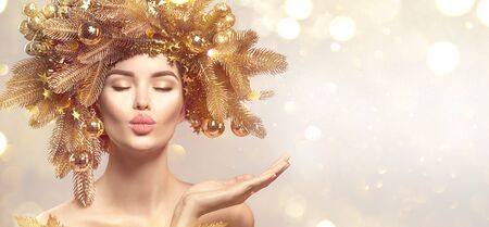 Christmas Woman with golden spruce tree wreath hairstyle on blurred pastelの写真素材