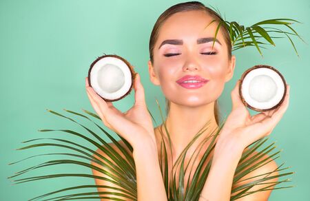 Beauty Woman with coconut Portrait. Spa model girl holding coco nut. Pretty young brunette woman face. Skin care. Youth. Treatment. Beautiful Fashion Model Girl Face. Perfect Skin. Health careの写真素材