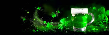 St. Patric's Day Green Beer pint over dark green background, decorated with shamrock leaves. Patric Day pub party, celebrating. Mug of Green beer close-up. Traditional Irish festival. Border artの写真素材
