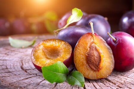 Plum. Healthy juicy ripe organic plums fruit close-up, on wooden table. Prune. Sweet fruit dessert. Organic bio fruitsの写真素材