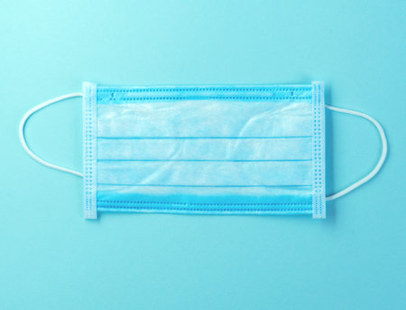 Doctor mask, coronavirus protection concept over blue background. Breathing medical respiratory...