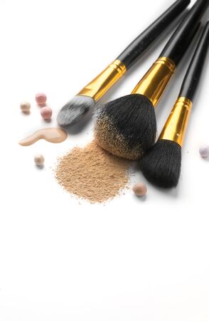Cosmetic liquid foundation or cream, loose face powder, various brushes for apply makeup. Make up concealer smear and powder isolated on a white background. Products for Perfect face skin makeup.の写真素材