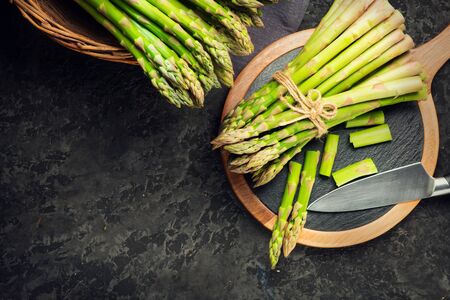 Asparagus. Fresh raw organic green Asparagus sprouts closeup. On black table background. Healthy vegetarian food. Raw vegetables, market. Healthy eating concept, diet, dieting. Top view, flat layの写真素材