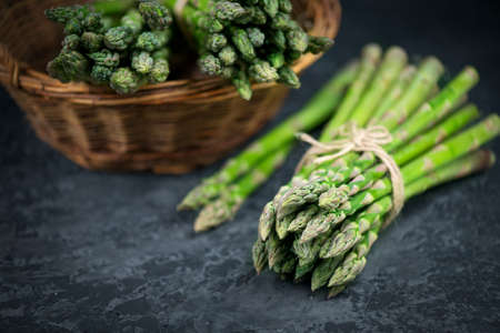 Asparagus. Fresh raw organic green Asparagus sprouts closeup. On black slate table background. Healthy vegetarian food. Raw vegetables, market. Healthy eating concept, diet, dieting. Top viewの写真素材