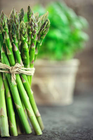 Asparagus. Fresh raw organic green Asparagus sprouts closeup. Over wooden table. Healthy vegetarian food. Raw vegetables, market. Healthy eating, diet, dieting concept. Vertical imageの写真素材